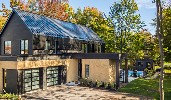 Scandinavian-style 2-storey house, in black and pale wood, all glass garage doors in Black
